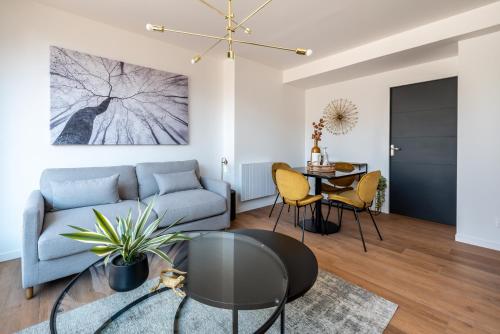 a living room with a couch and a table at DOWNTOWN ROOFTOP - CENTRE VILLE - WiFi - TERRASSE - NETFLIX in Amiens