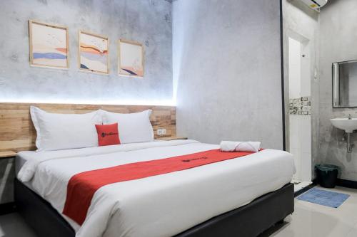 um quarto com uma cama grande e um cobertor vermelho em RedDoorz @ Sekip Medan em Medan