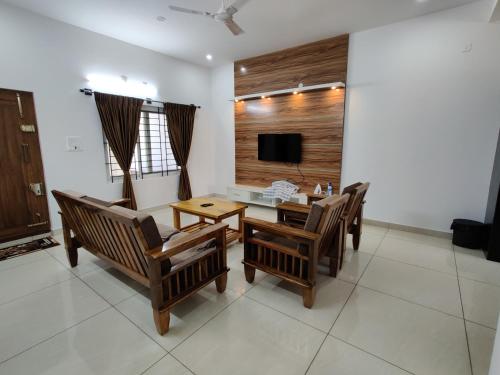 sala de estar con mesa, sillas y TV en SS LUXURY Comforts-Two bedroom en Chikmagalūr