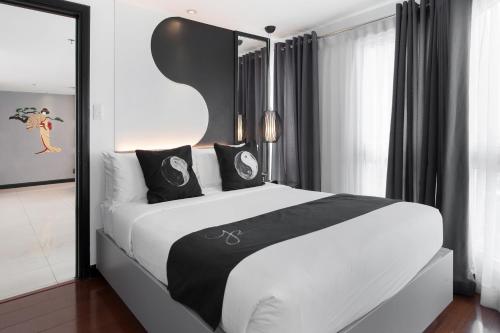 a bedroom with a large white bed with black pillows at Y2 Residence Hotel Managed by HII in Manila