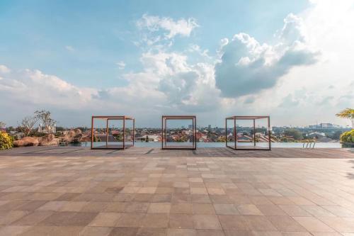 a group of metal structures on a patio with a lake at RedLiving Apartemen Grand Kamala Lagoon - Pekayon Tower Barclay North in Pekayon Satu