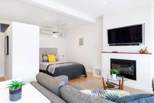 a living room with a couch and a fireplace at Modern Stylish Self-contained Studio Apartment in Burnside