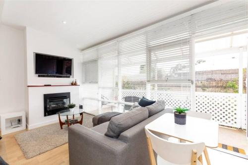 a living room with a couch and a table at Modern Stylish Self-contained Studio Apartment in Burnside