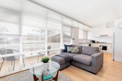 a living room with a couch and a table at Modern Stylish Self-contained Studio Apartment in Burnside
