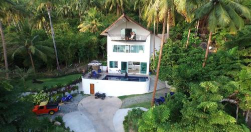 an aerial view of a white house with palm trees at Monkey Flower Villas in Koh Tao