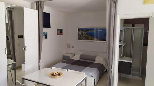 um pequeno quarto com uma cama e uma mesa em lu Ientu house in Otranto, Baia dei Turchi area em Alimini