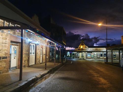 een lege straat 's nachts met een straatlicht bij Ten Dollar Town Motel in Gulgong
