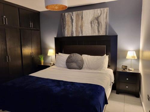 a bedroom with a large bed with blue and white sheets at Modern Apartment in Rosarito
