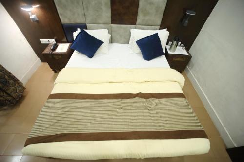 a bedroom with a large bed with blue pillows at The Byke Heritage Resort - Matheran in Matheran