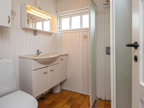 a bathroom with a sink and a toilet and a window at Holiday home Grenaa VI in Grenå
