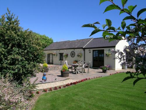 a house with a garden and a child in the yard at Y Stabl in Fishguard