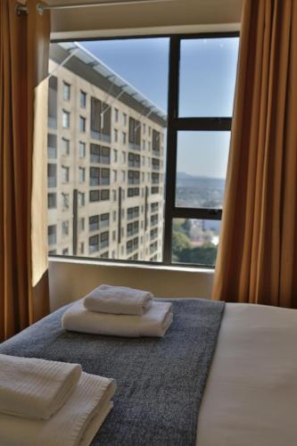 a hotel room with two towels on a bed with a window at WeStay Westpoint Apartments in Johannesburg