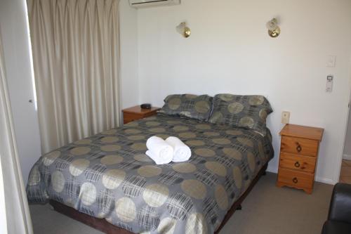 a bedroom with a bed with two towels on it at Illawong Beach Resort in Mackay