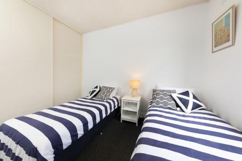 zwei Betten nebeneinander in einem Zimmer in der Unterkunft At the Beach, Debra Court Unit 5 in Forster
