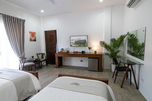 a hotel room with two beds and a desk at Thistle Inn in Panglao