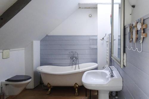 une salle de bain avec une baignoire et un lavabo dans l'établissement Stone House in Plouezec near Goelo Coast, à Plouézec