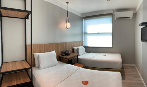Habitación pequeña con 2 camas y ventana en Go Hotels Bacolod, en Bacolod