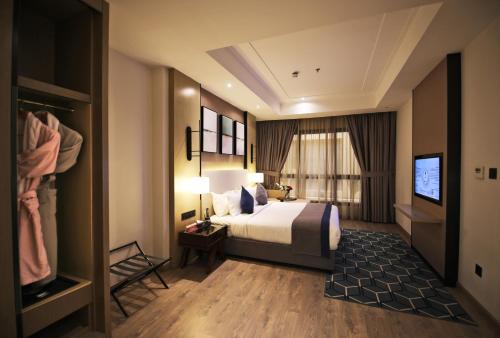 a hotel room with a bed and a television at Braira Al Yarmouk in Riyadh