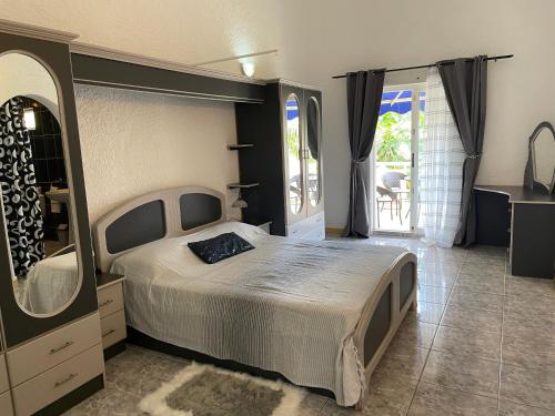 ein Schlafzimmer mit einem Bett und einem großen Spiegel in der Unterkunft Villa Dreamteam in Flic-en-Flac