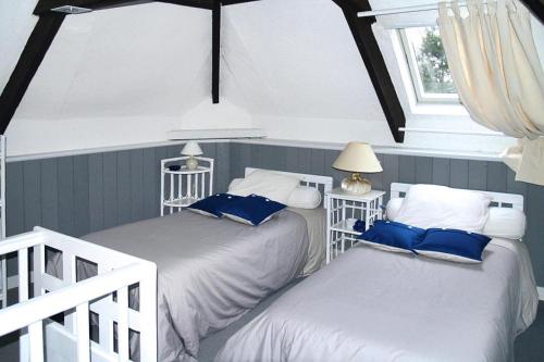 deux lits jumeaux dans une chambre avec fenêtre dans l'établissement Duplex in Fécamp with Harbor Views, à Fécamp