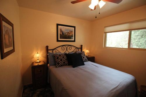 1 dormitorio con 1 cama y ventilador de techo en Cedar Mountain Lodge, en Oakhurst