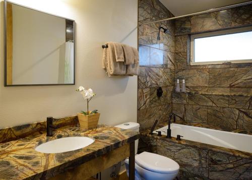 a bathroom with a sink and a toilet and a tub at Alpenglow 1 in Yosemite West