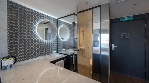 uma casa de banho com um lavatório e um espelho em Lavalse Hotel em Busan