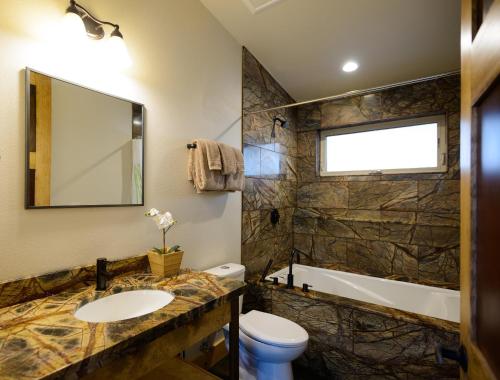een badkamer met een toilet, een wastafel en een bad bij Alpenglow 3 in Yosemite West