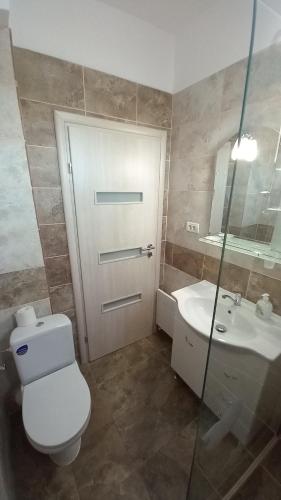 a bathroom with a toilet and a sink and a door at Apartament Matei in Tulcea