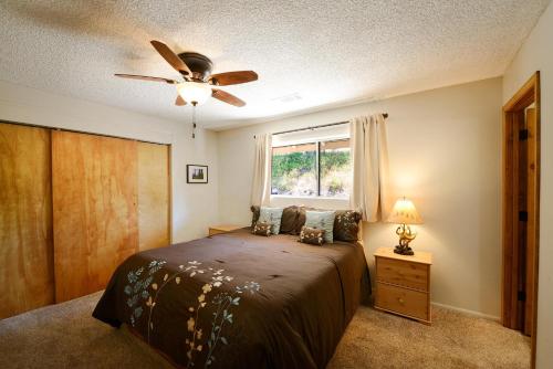 a bedroom with a bed with a ceiling fan and a window at Blue Bird Ranch in Oakhurst