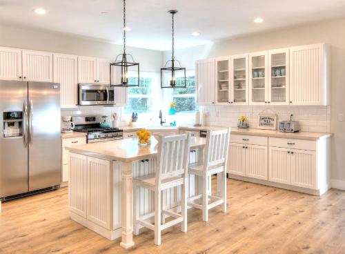 uma cozinha com armários brancos e um frigorífico de aço inoxidável em Craftsman Cottage em Yosemite West