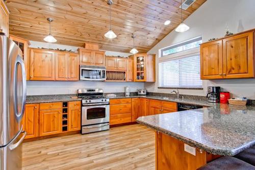 a large kitchen with wooden cabinets and stainless steel appliances at Bears Den & Little Bear in Yosemite West