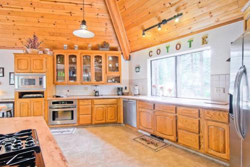 a large kitchen with wooden cabinets and a large window at Coyote Creek in Yosemite West