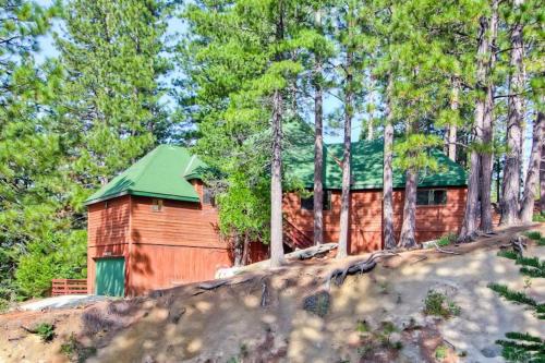 a wooden cabin with a green roof in the woods at Coyote Creek in Yosemite West