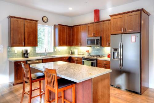 a kitchen with wooden cabinets and a stainless steel refrigerator at Eureka in Yosemite West