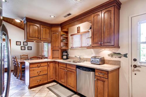 a kitchen with wooden cabinets and a sink at Fishermen’s Oasis in Oakhurst