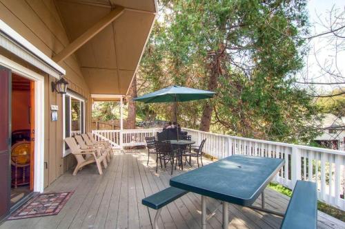 a porch with a table and an umbrella at Fishermen’s Oasis in Oakhurst