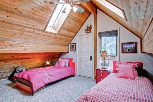 a bedroom with two beds and a wooden ceiling at Edelweiss in Yosemite West