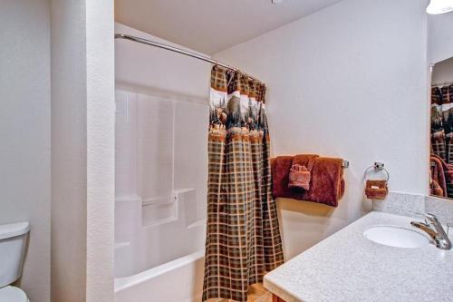 La salle de bains est pourvue d'un rideau de douche et d'un lavabo. dans l'établissement Explorers Retreat, à Yosemite West