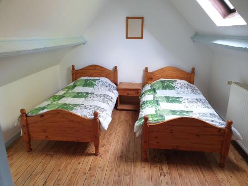 two twin beds in a room with wooden floors at Cottage in Normandy near Barneville-Carteret in Saint-Sauveur-le-Vicomte