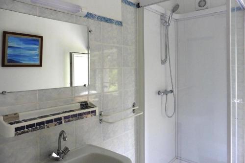 a bathroom with a sink and a shower with a mirror at Semi-detached house, St Sauveur-le-Vicomte in Saint-Sauveur-le-Vicomte