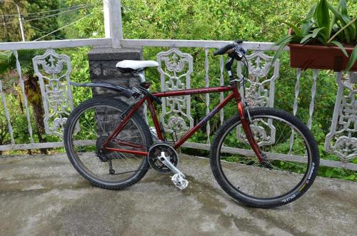 a red bike parked next to a fence at TJ Guest House in Makhinjauri