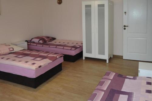 Cette chambre comprend 3 lits et une porte. dans l'établissement holiday home, Miedzyzdroje, à Międzyzdroje