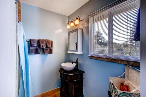un baño con lavabo y espejo en Harmony Hilltop Hideaway, en Oakhurst