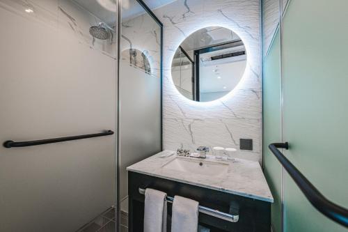 a bathroom with a sink and a mirror at Lavalse Hotel in Busan