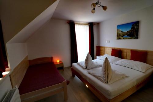 a bedroom with a bed and a window and a staircase at Ferienwohnungen ARIKOGEL Bad Goisern in Bad Goisern
