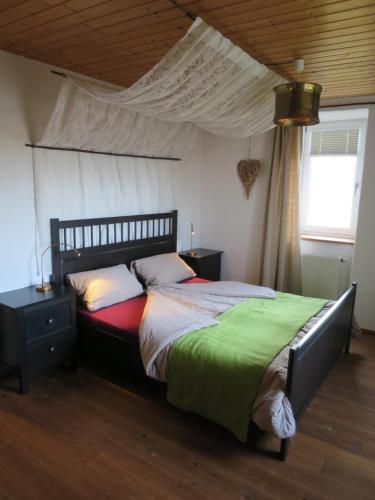 ein Schlafzimmer mit einem großen Bett mit Baldachin in der Unterkunft Alpaka-Ferien in Wiechs am Randen