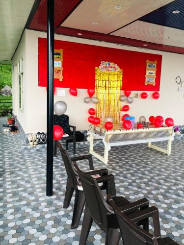 a room with chairs and a red wall at Paradise Inn by HBR in Dharmsala