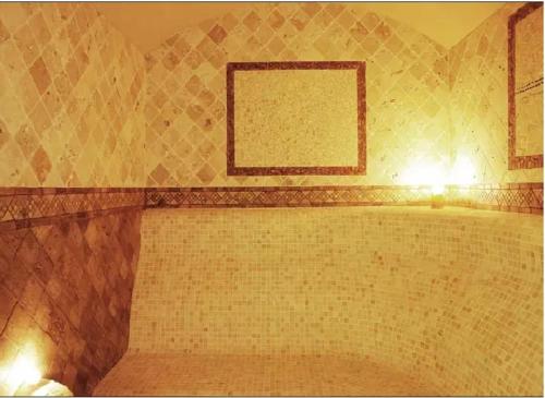 a bathroom with a tub with a brick wall at Къща за гости Мускат 2 in Aheloy