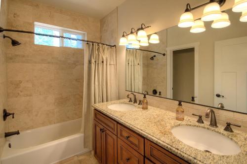 Un baño con dos lavabos y un espejo grande. en River Rock Retreat, en Yosemite West